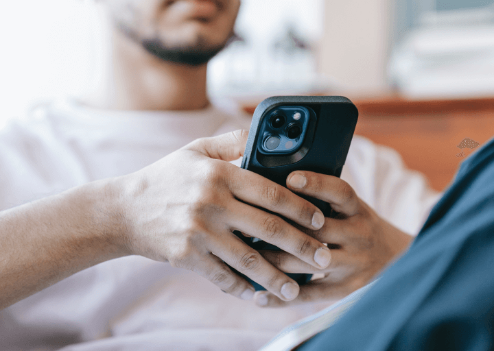 Man looks at iphone trying to contact